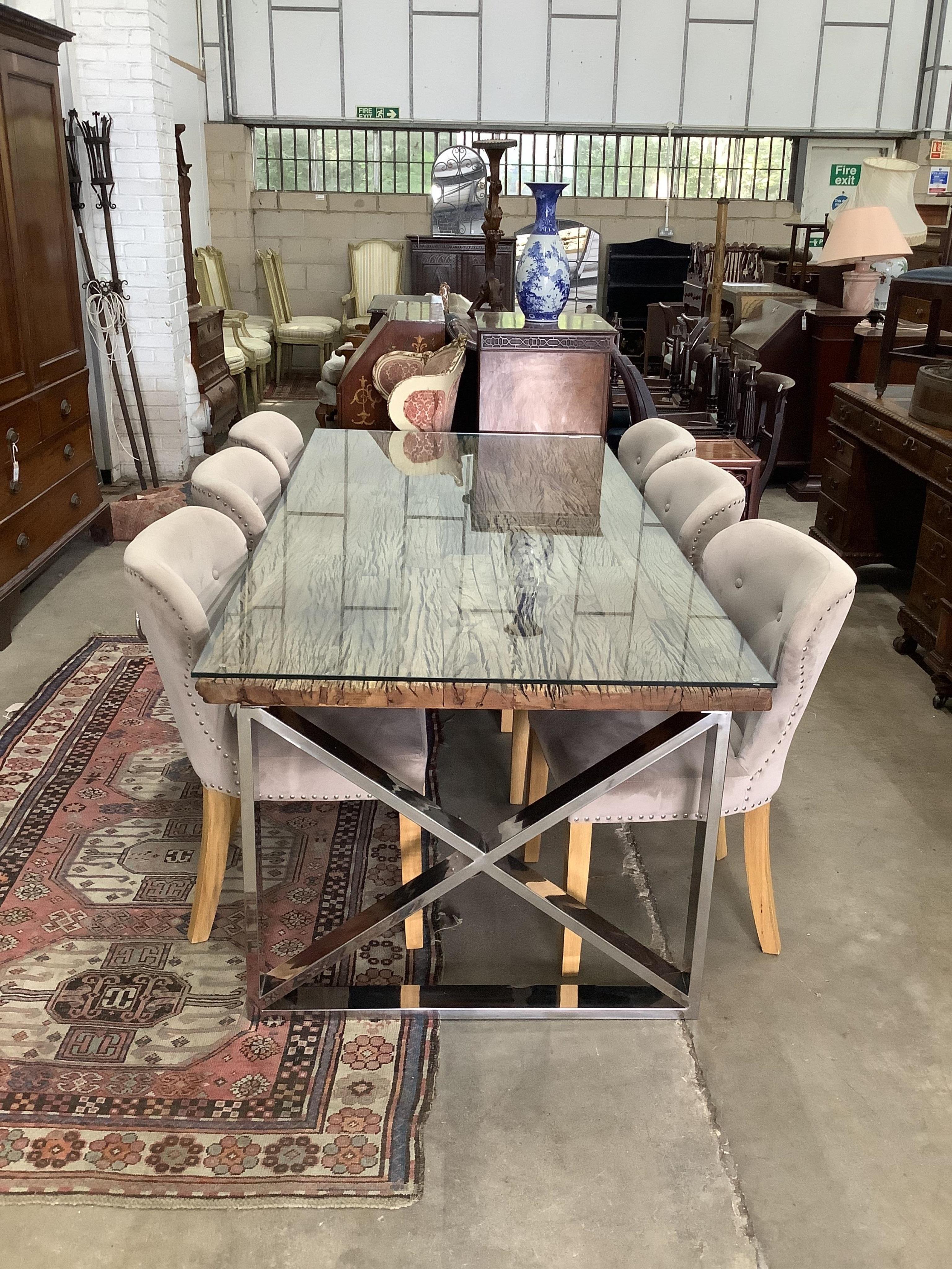 A Contemporary glass top weathered timber and chrome dining table, the top made from old train rail track woods, width 221cm, depth 102cm, height 77cm, and a set of six upholstered dining chairs. Condition - good